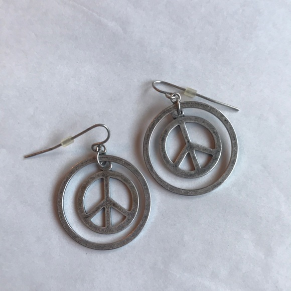 Jewelry - Silver in color dangling peace sign earrings.